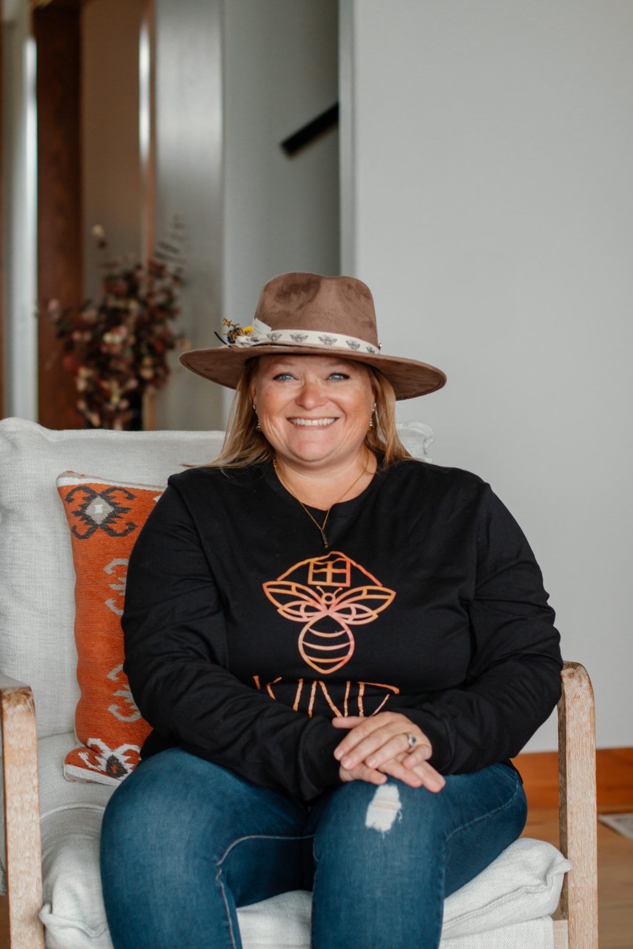 Melissa Shields seated in a hat and bee-logo shirt