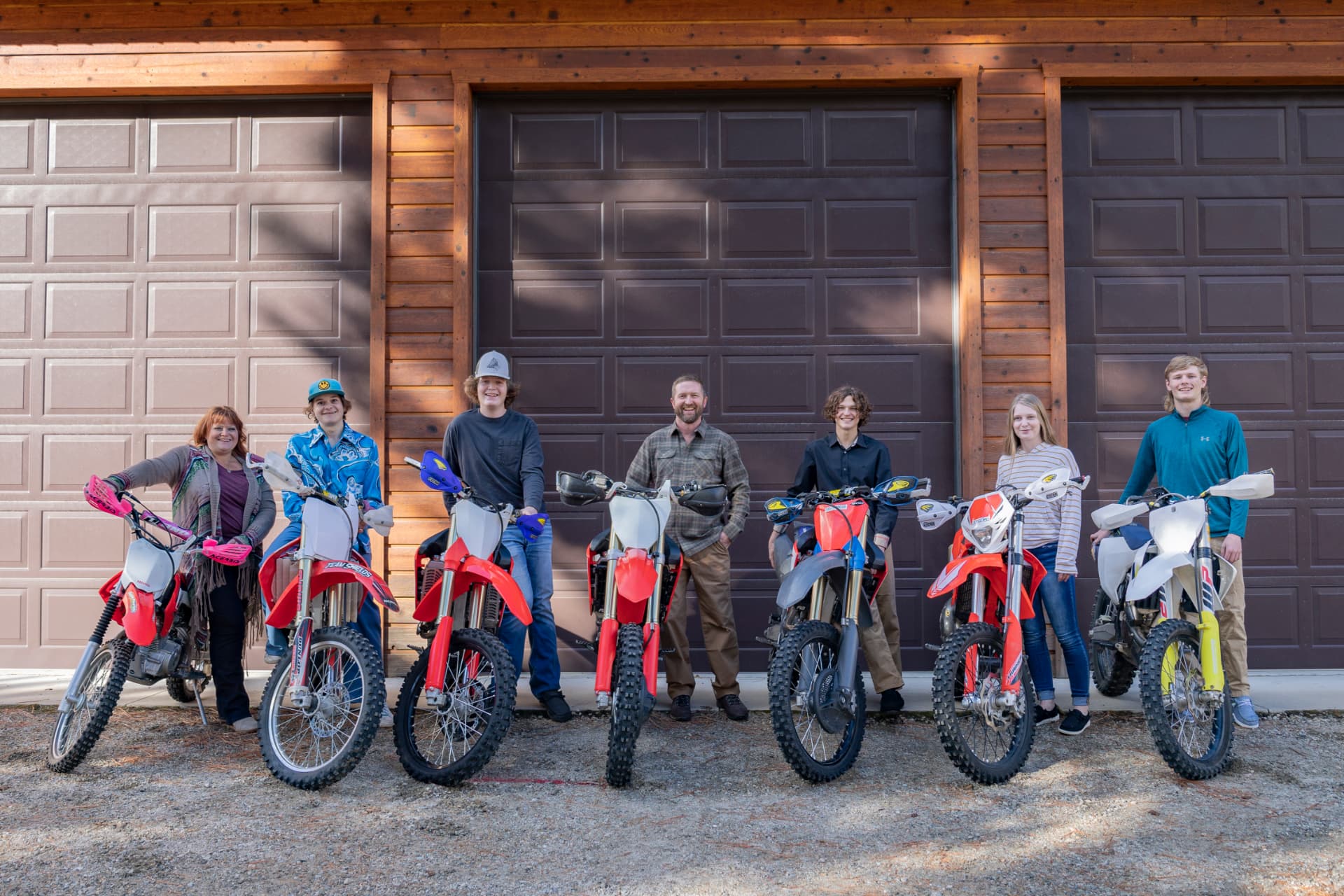 Melissa Shields and her family standing with their dirt bikes in front of their garage